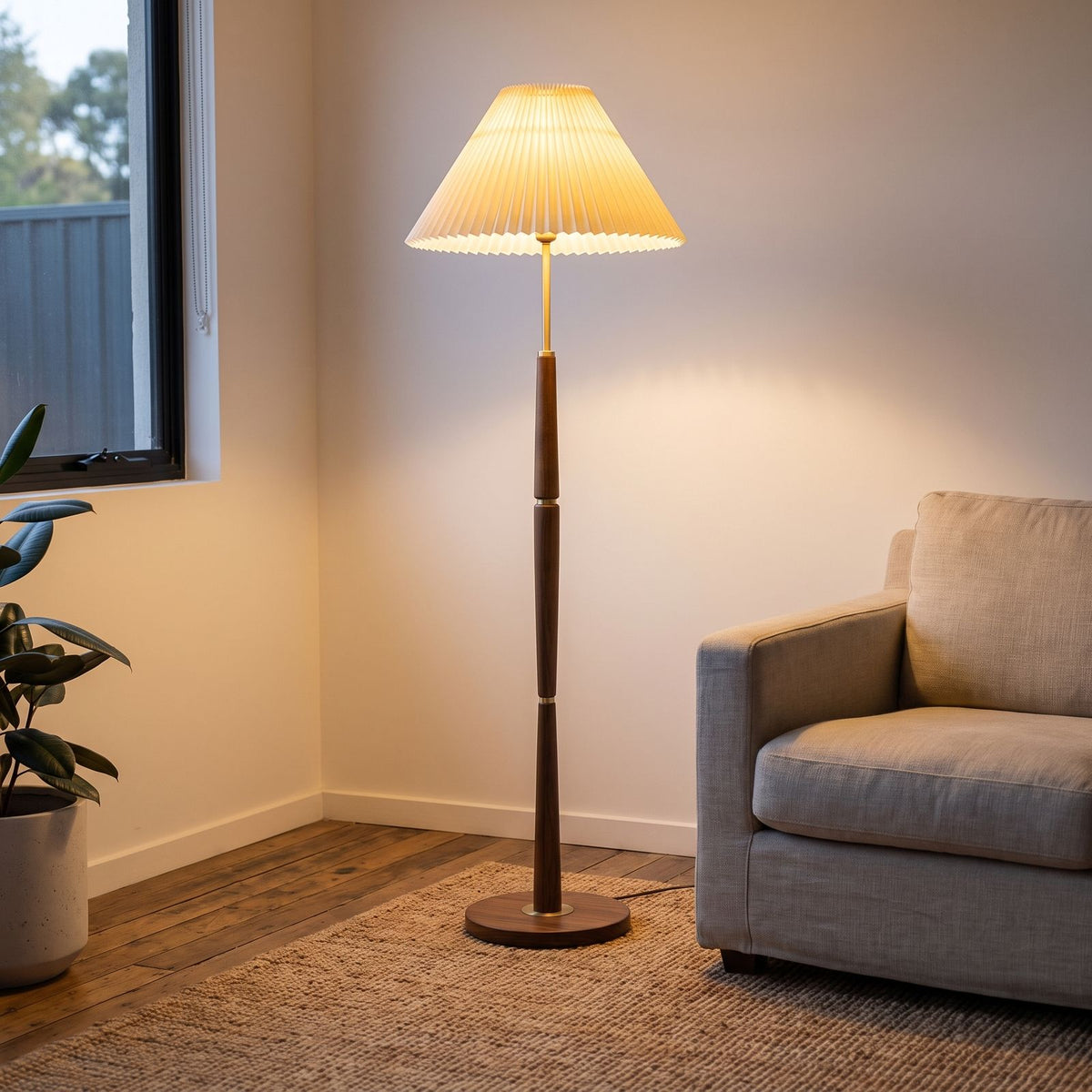 Floor lamp with pleated shade beside an armchair
