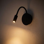 360-Degree Adjustable Silicone LED Wall Light glowing on a plaster wall at night