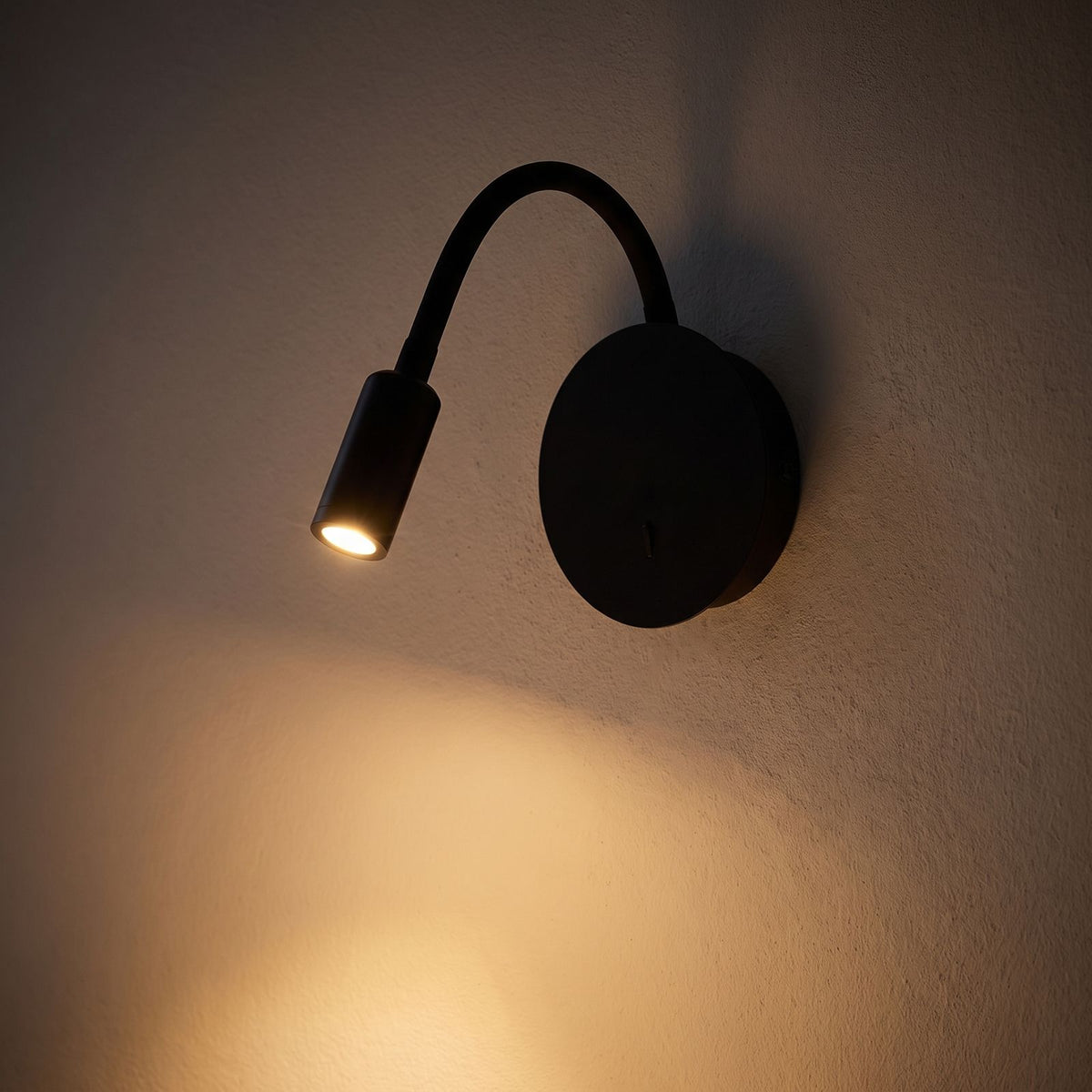 360-Degree Adjustable Silicone LED Wall Light glowing on a plaster wall at night
