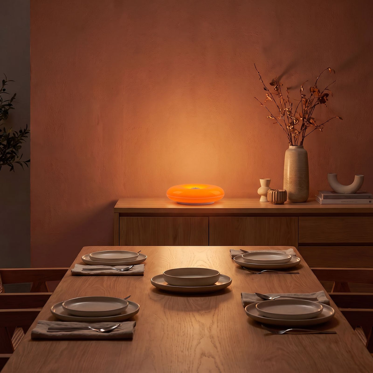 Orange acrylic donut lamp on a sideboard in a dining room at night