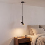 Adjustable Black Metal Cylinder Spotlight Pendant Light over a bedside table