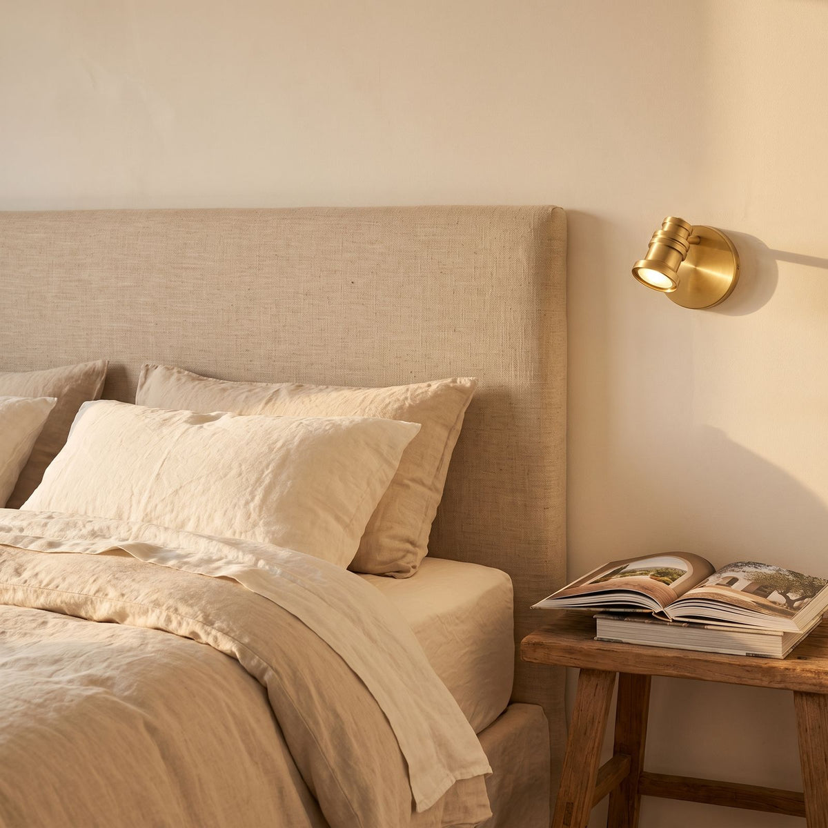 Adjustable Brass Spotlight Dimmable LED Wall Light beside a bed in a bedroom