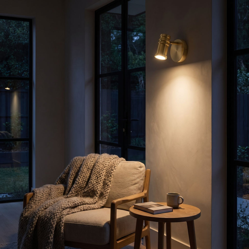 Adjustable Brass Spotlight Dimmable LED Wall Light beside an armchair at night