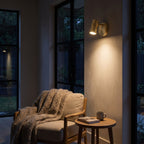Adjustable Brass Spotlight Dimmable LED Wall Light beside an armchair at night