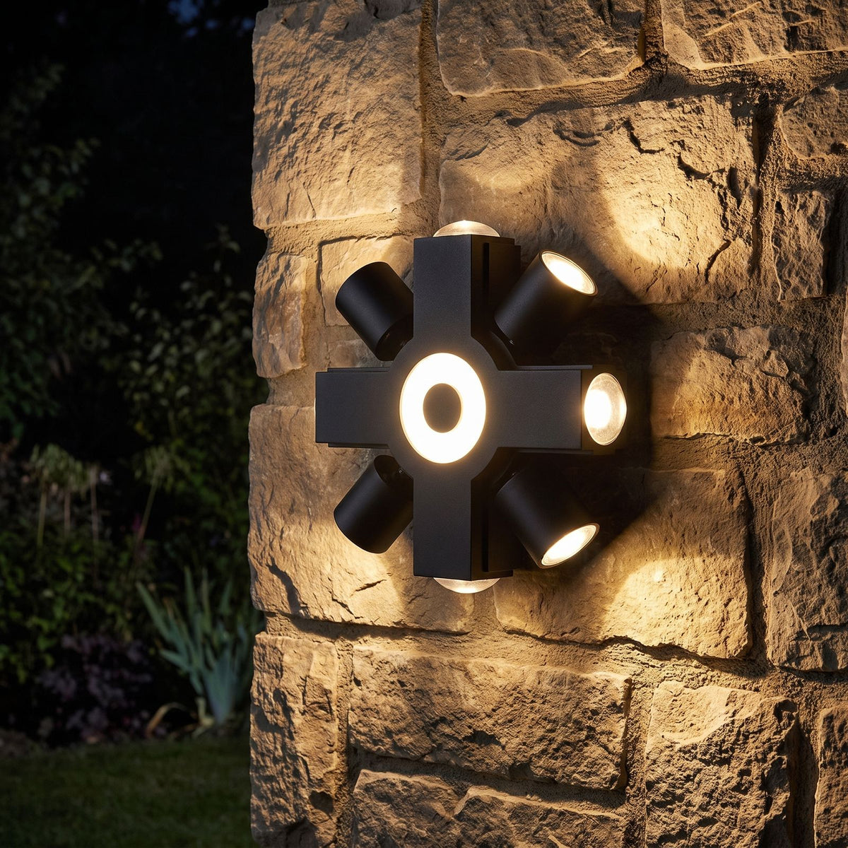 Adjustable Multi Head Outdoor Wall Light glowing on a garden wall at night