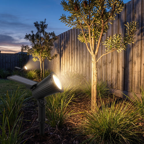 Adjustable Spike Solar Spotlight Garden Light in a garden bed at dusk