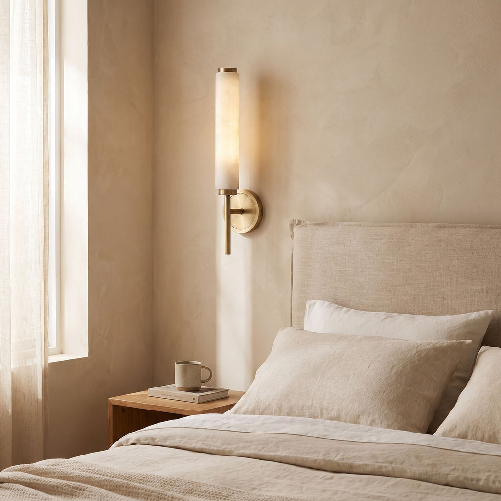 Alabaster Candle Brass Wall Sconce on a bedroom wall beside the bed