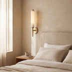 Alabaster Candle Brass Wall Sconce on a bedroom wall beside the bed