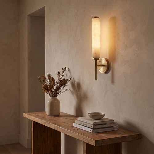 Alabaster Candle Brass Wall Sconce in a hallway above a timber console