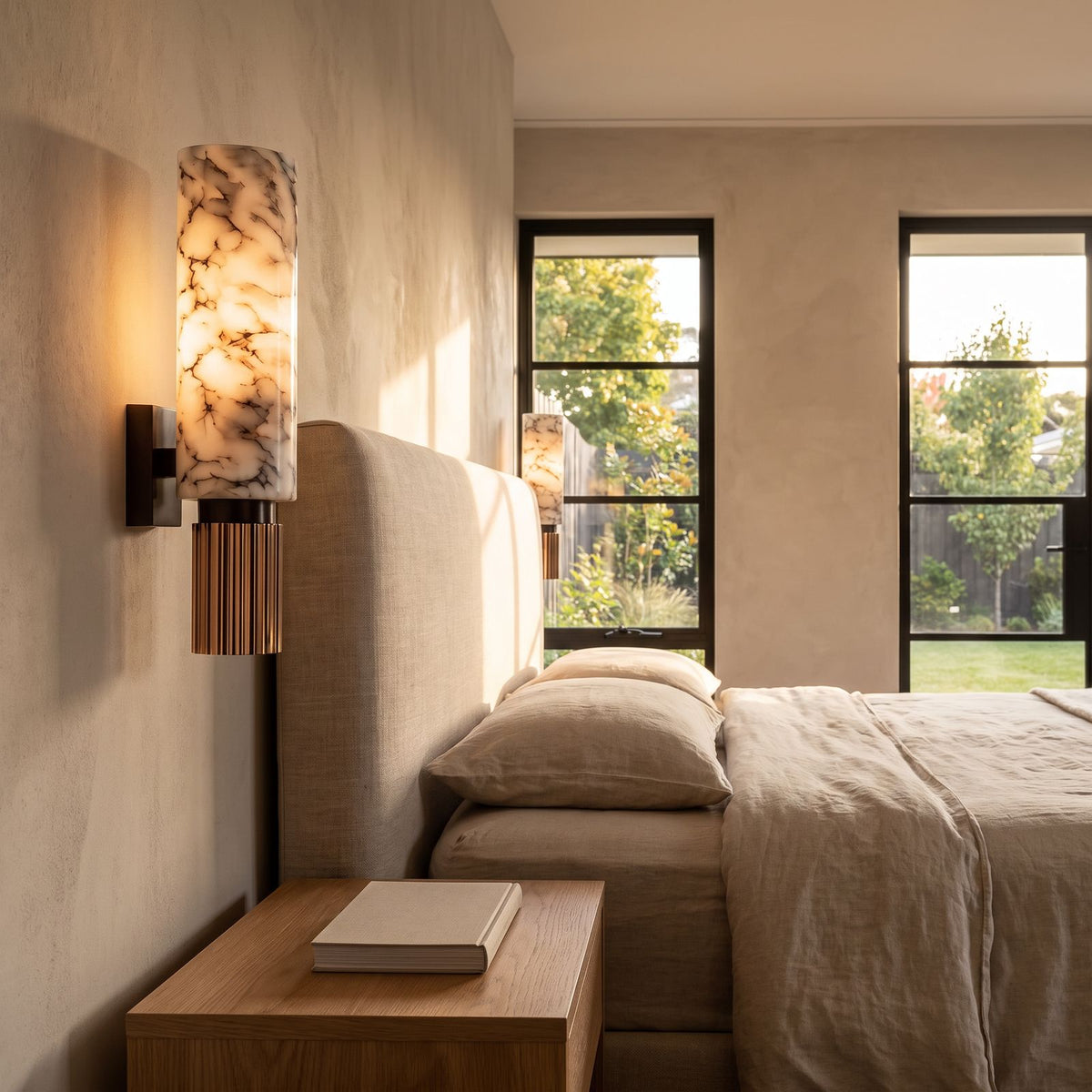 Alabaster Cylinder and Fluted Copper Wall Light beside a bed in a bedroom