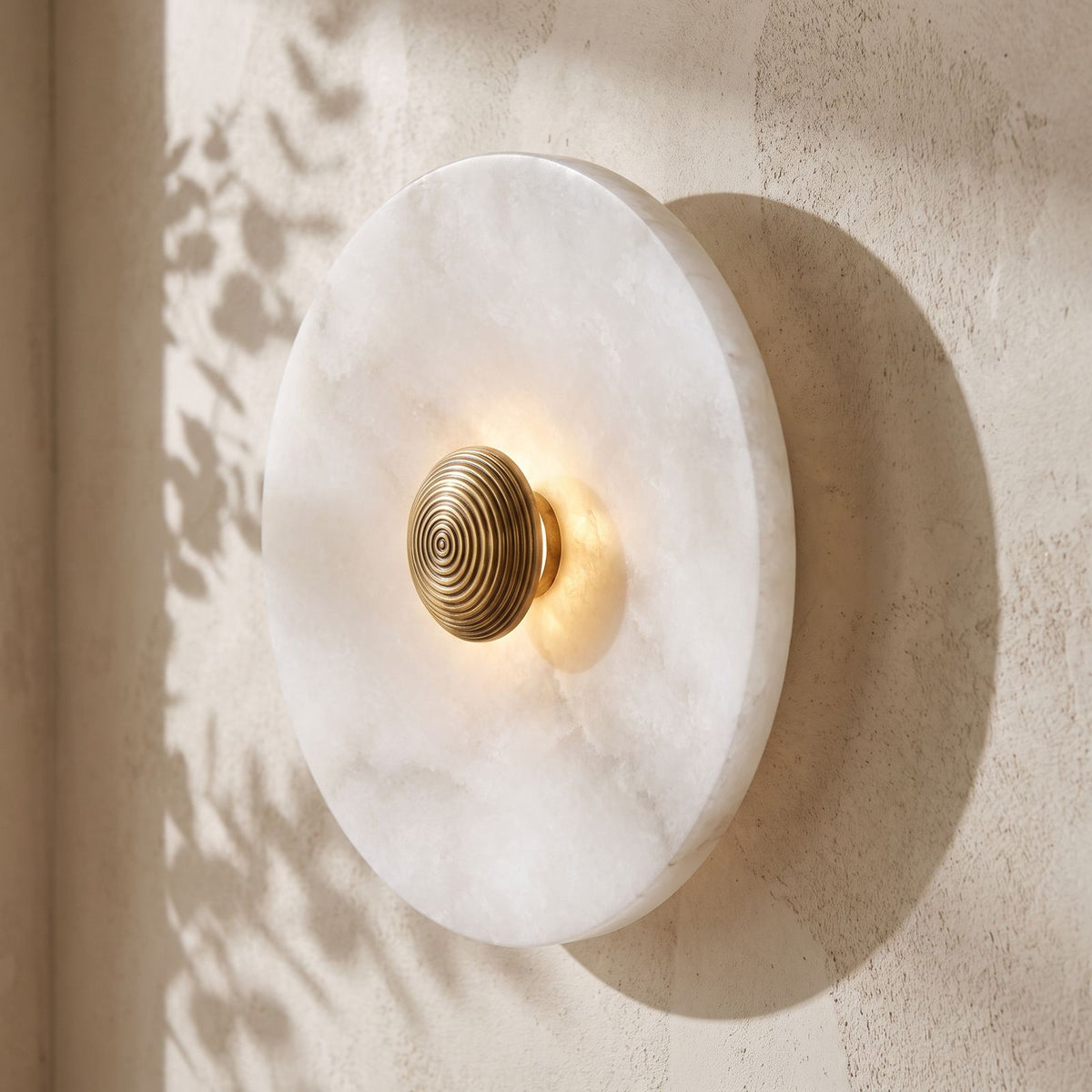 Alabaster Disc Wall Light on a plaster wall, angled close view