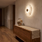 Alabaster Disc Wall Light above a timber console in an entry hallway