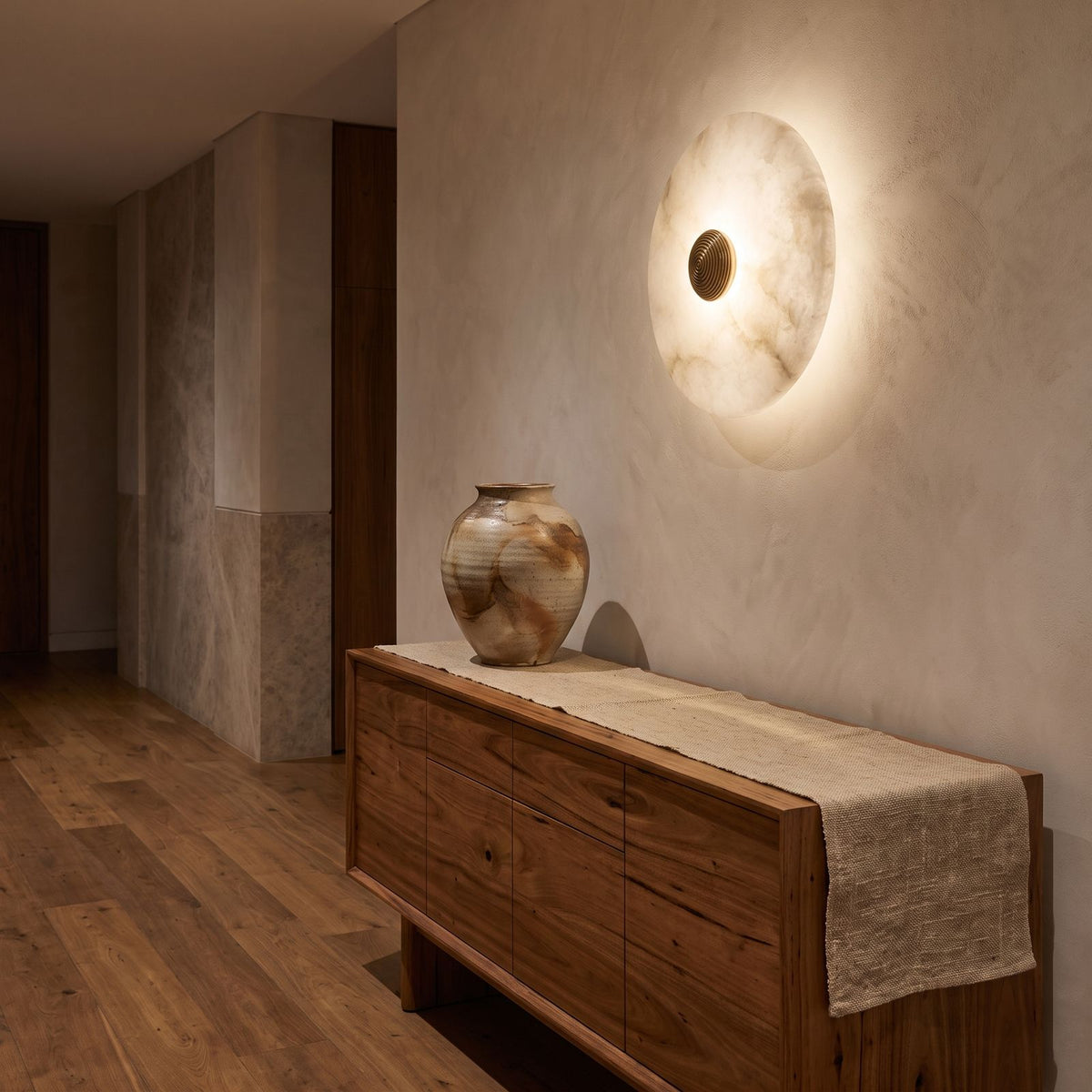 Alabaster Disc Wall Light above a timber console in an entry hallway