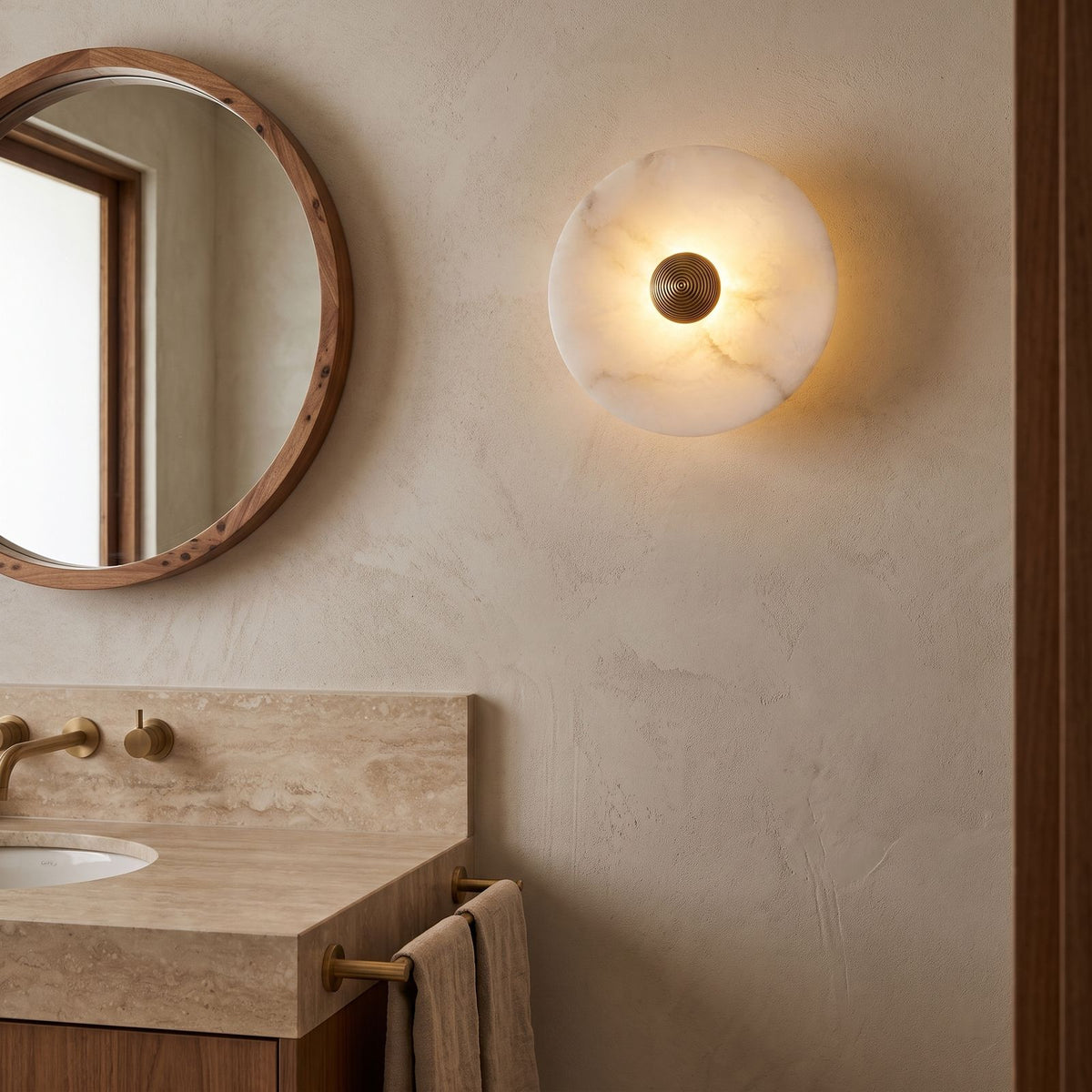 Alabaster Disc Wall Light beside a round mirror in a powder room