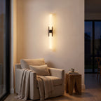 Alabaster effect cylinder wall light above an armchair in a reading corner