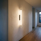 Alabaster Effect Cylinder LED Wall Light lighting a plaster hallway wall in the evening