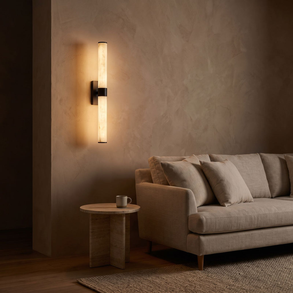 Alabaster Effect Cylinder LED Wall Light on a clay toned living room wall at night