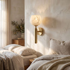 Marble Flower Petal Brass Wall Sconce on a bedroom wall beside the bed