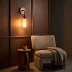 Alabaster-Look Glass Cylinder Drop Wall Light beside an armchair at night