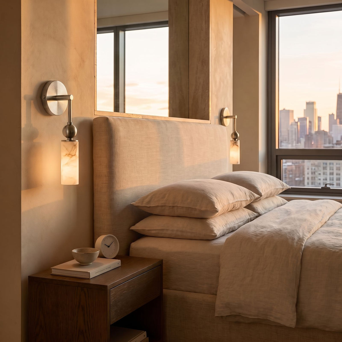 Alabaster-Look Glass Cylinder Drop Wall Light in nickel, beside a bed in a bedroom