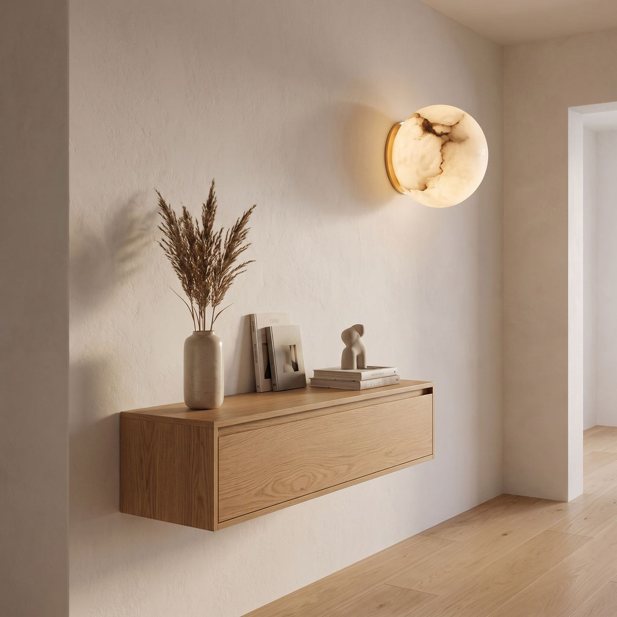 Alabaster Orb Wall Light with Gold Base in a hallway above a timber console