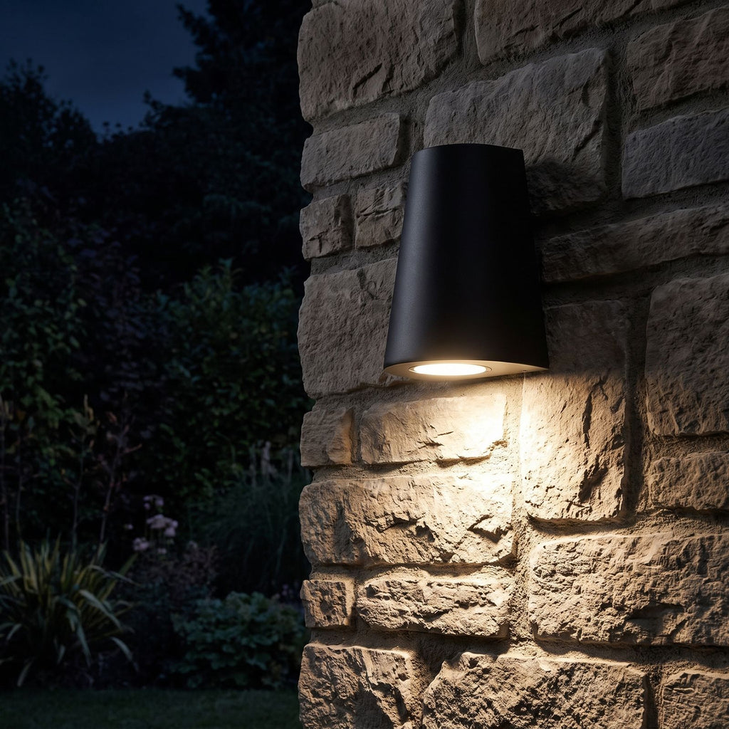 Aluminium COB LED Outdoor Wall Light glowing on a garden wall at night