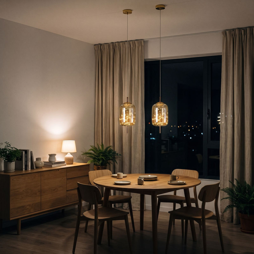 Two amber glass capsule pendants above a round oak dining table in an apartment at night