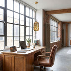 The amber glass capsule pendant in cold white above a desk in a warehouse loft home office by day