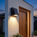 Angled Wedge Aluminium Downward Outdoor Wall Light beside a timber front door at dusk