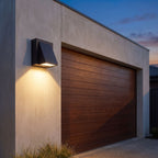 Angled wedge downward outdoor wall light beside a garage door at dusk