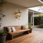 Antique Brass Glass Outdoor Wall Lantern above a bench on a covered patio