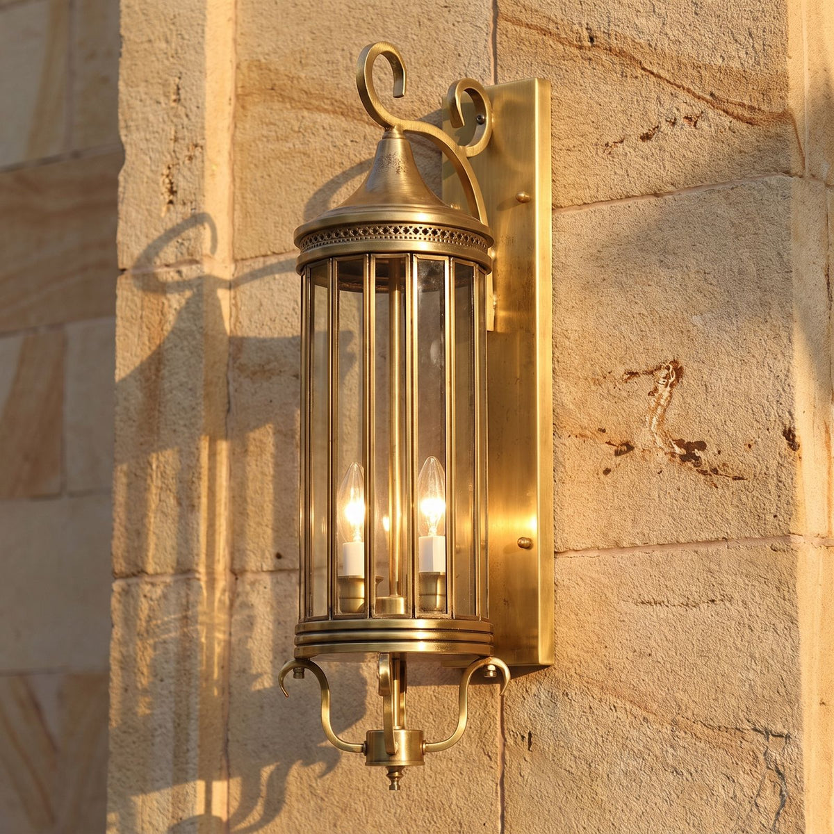 Arabian Style Brass and Glass Outdoor Wall Lantern, close view at 45 degrees on a stone wall