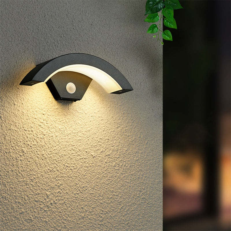 Arc wall light with motion sensor housing on a rendered wall