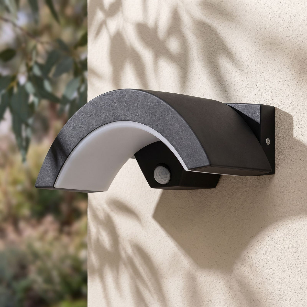Arc Motion Sensor Outdoor Wall Light on a rendered wall, angled close view