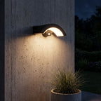 Arc Motion Sensor Outdoor Wall Light lighting a concrete wall at night