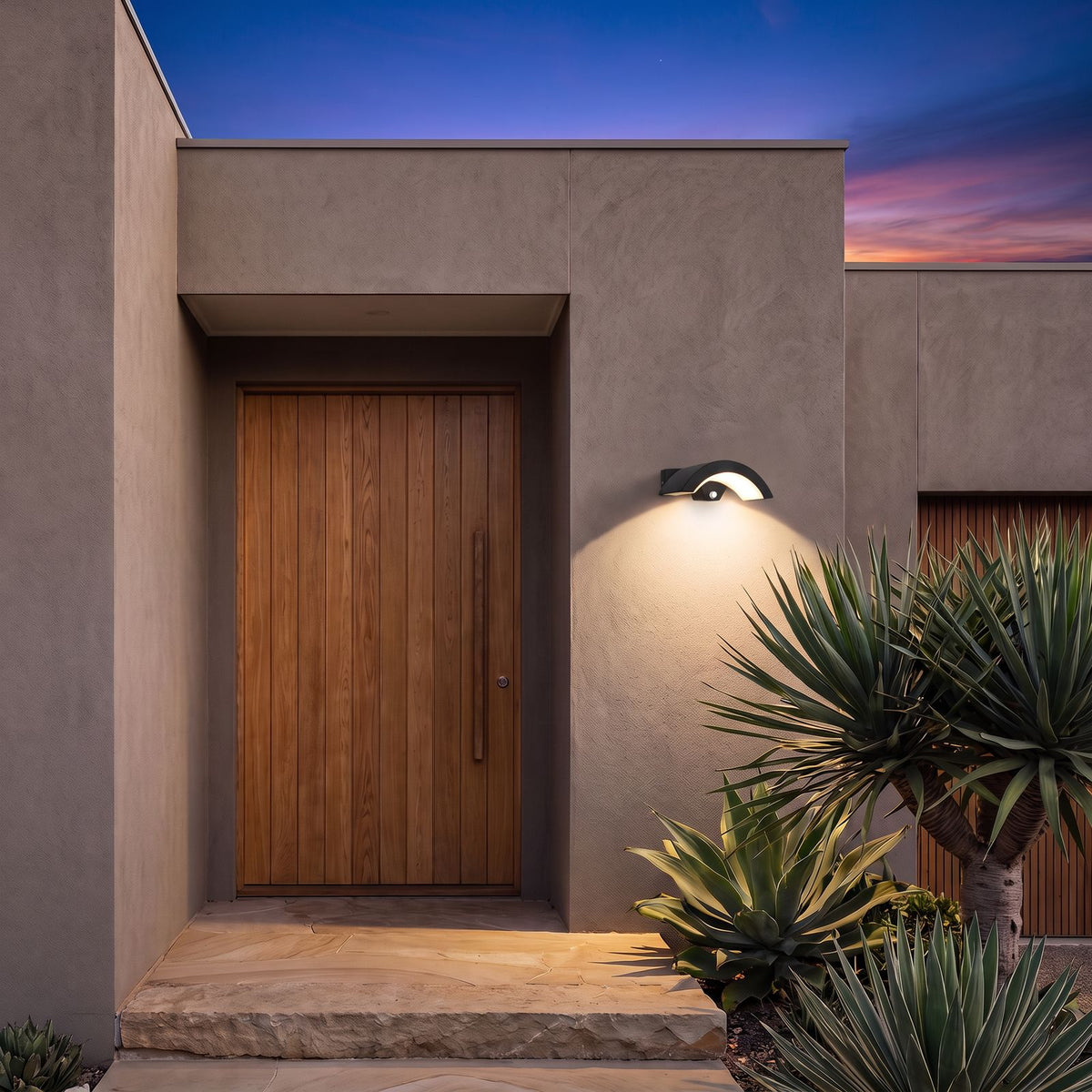 Arc Motion Sensor Outdoor Wall Light beside the oak front door of a contemporary rendered home at dusk