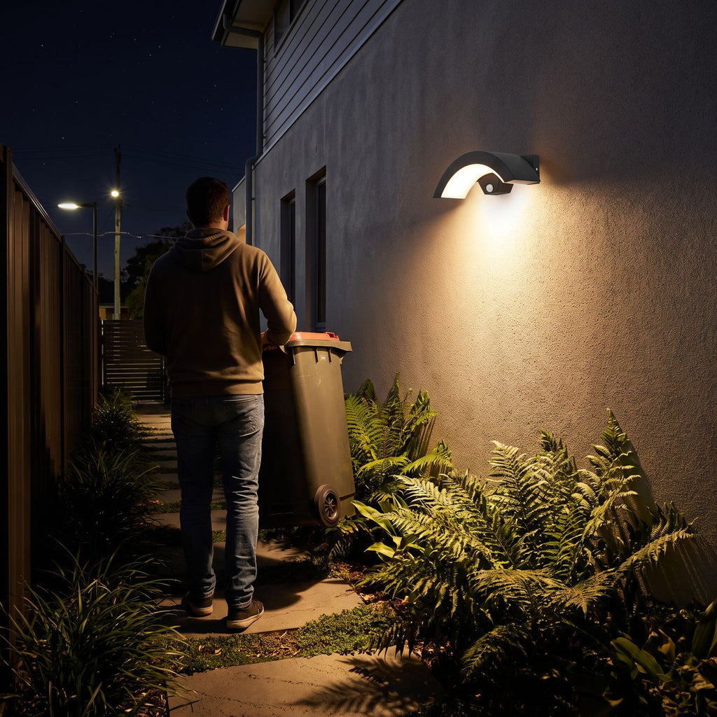 Arc Motion Sensor Outdoor Wall Light switching on as a person walks along a side path at night