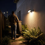 Arc Motion Sensor Outdoor Wall Light switching on as a person walks along a side path at night