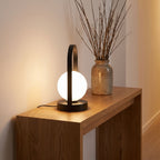 Arch frame frosted glass globe table lamp on an entry console