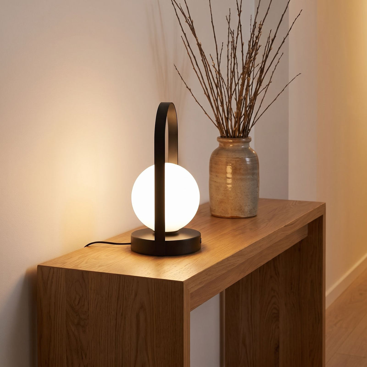 Arch frame frosted glass globe table lamp on an entry console
