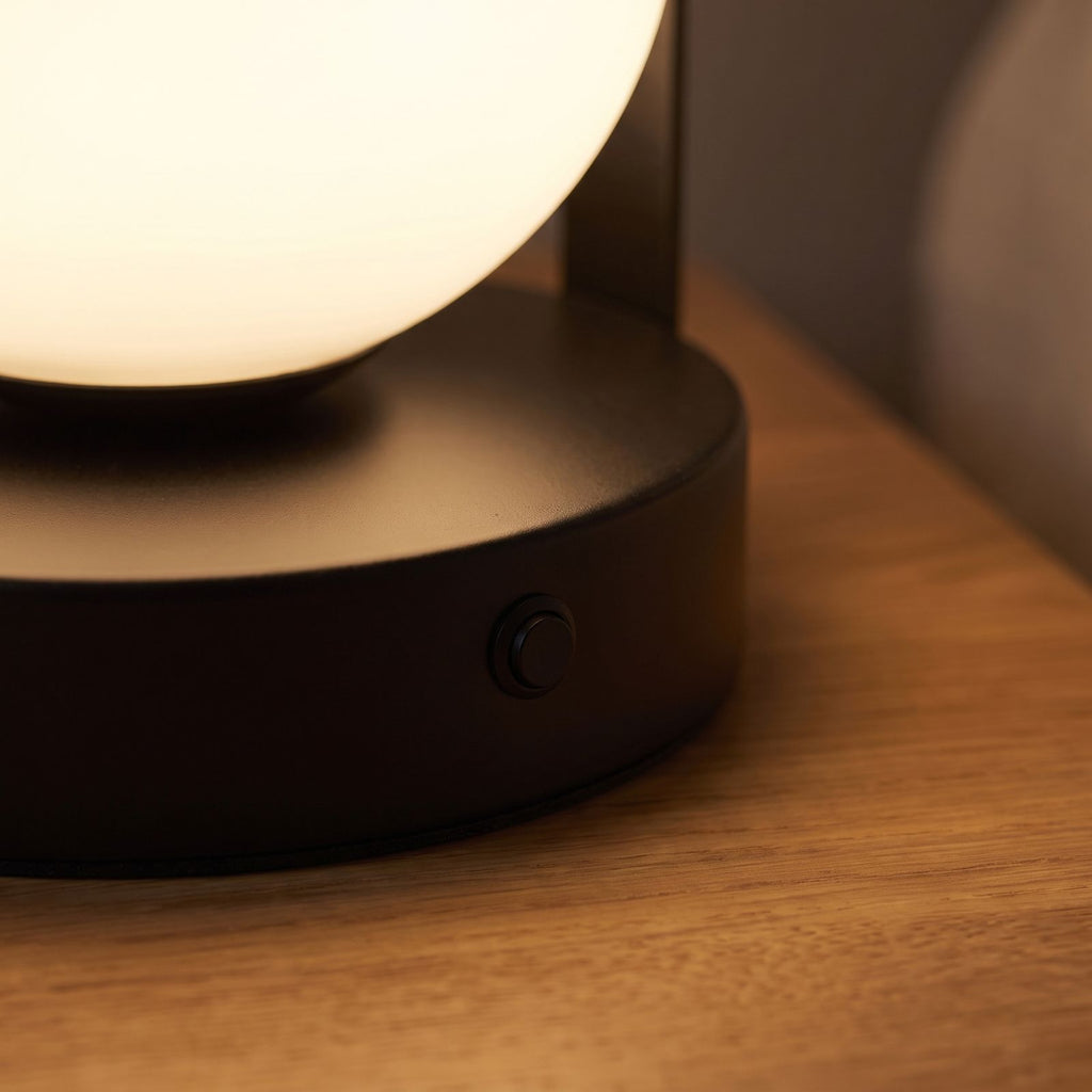 Close-up of the black base, button and glass globe