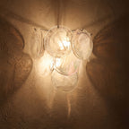 Art Deco Fan Textured Glass Wall Light glowing on a plaster wall at night