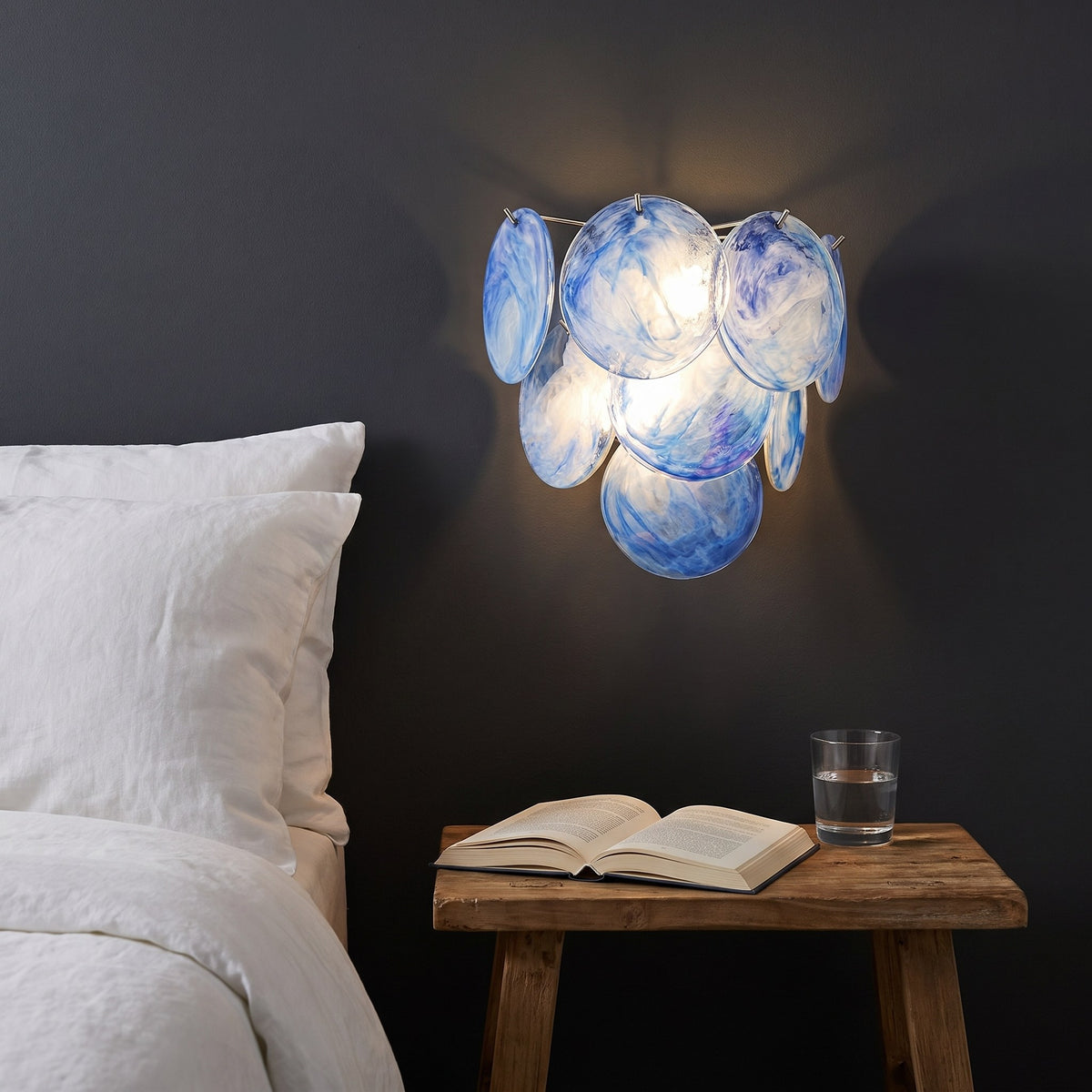 Art Deco Fan Textured Glass Wall Light in blue beside a bed
