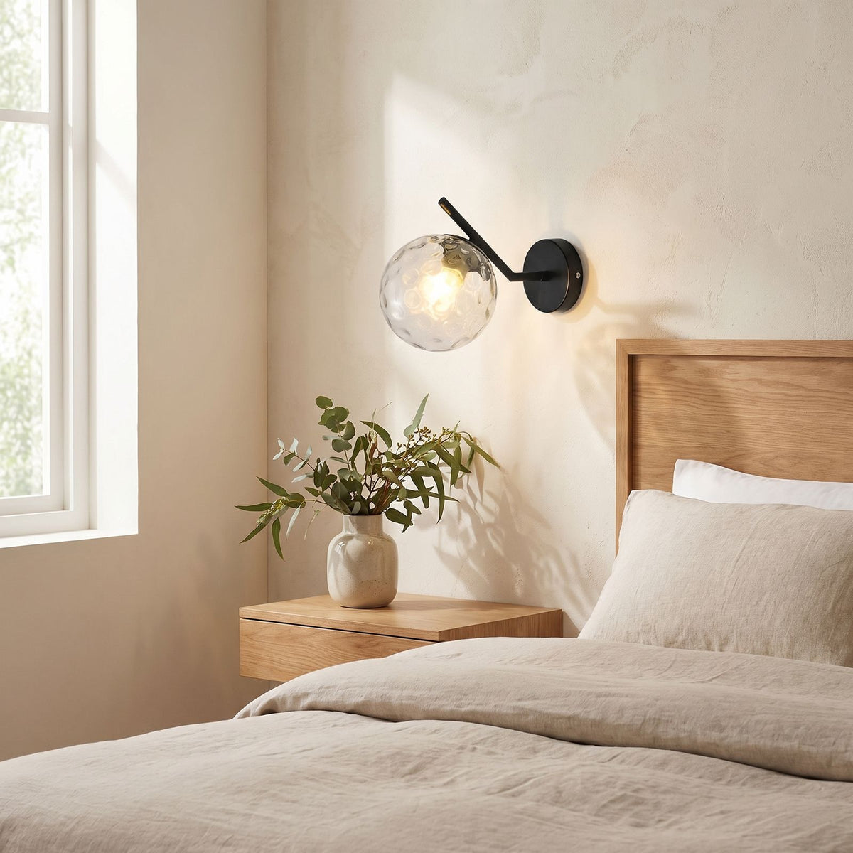 Art Deco Glass Ball Up Down Wall Sconce on a bedroom wall beside the bed
