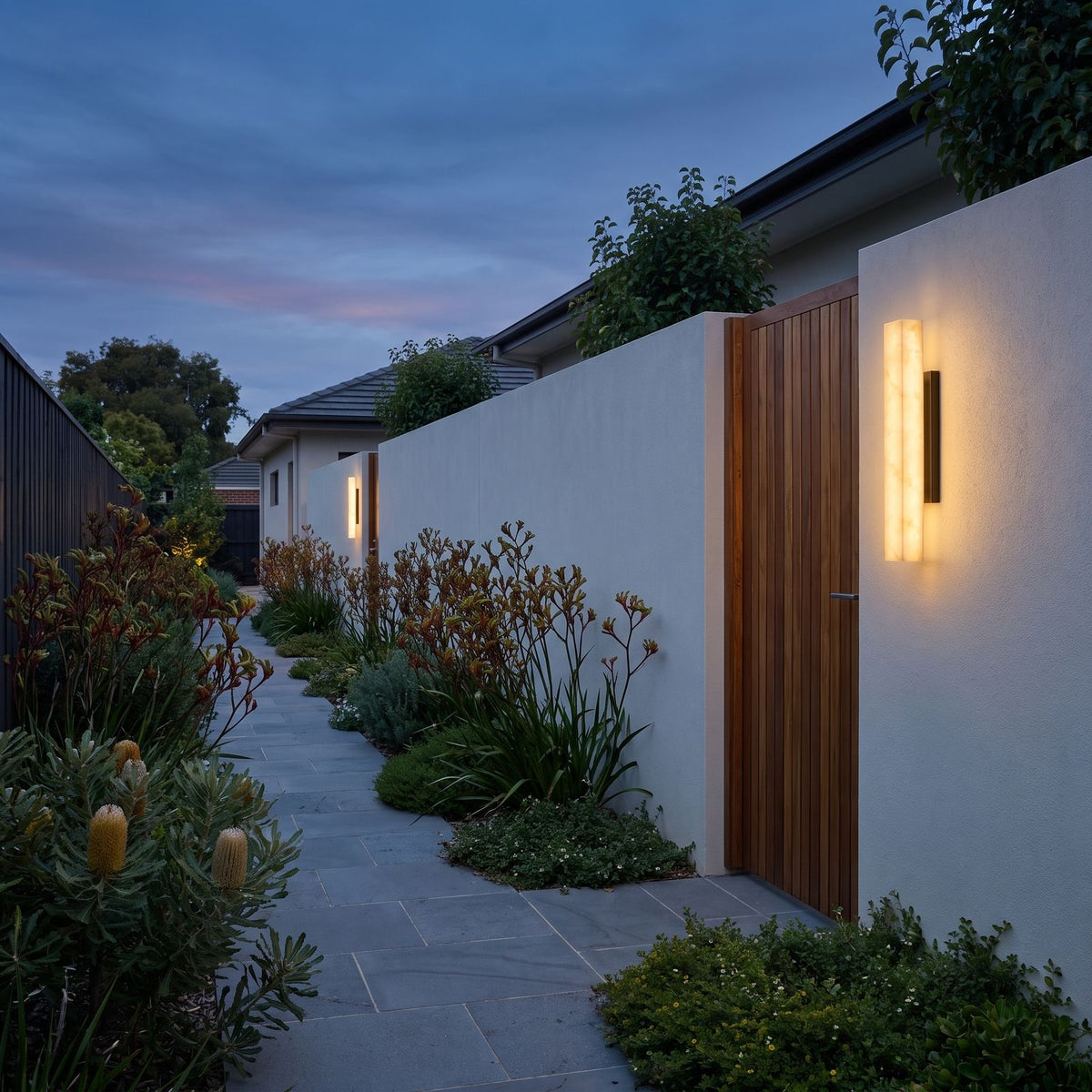 Artificial Alabaster Rectangular Outdoor Wall Light on a rendered garden wall beside a side gate at dusk