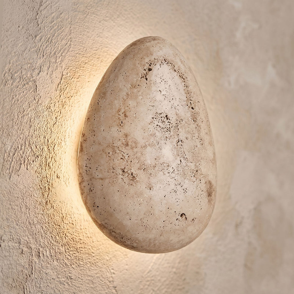 Backlit Floating Pebble Marble Wall Light, close view at 45 degrees on a plaster wall