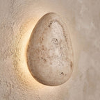 Backlit Floating Pebble Marble Wall Light, close view at 45 degrees on a plaster wall