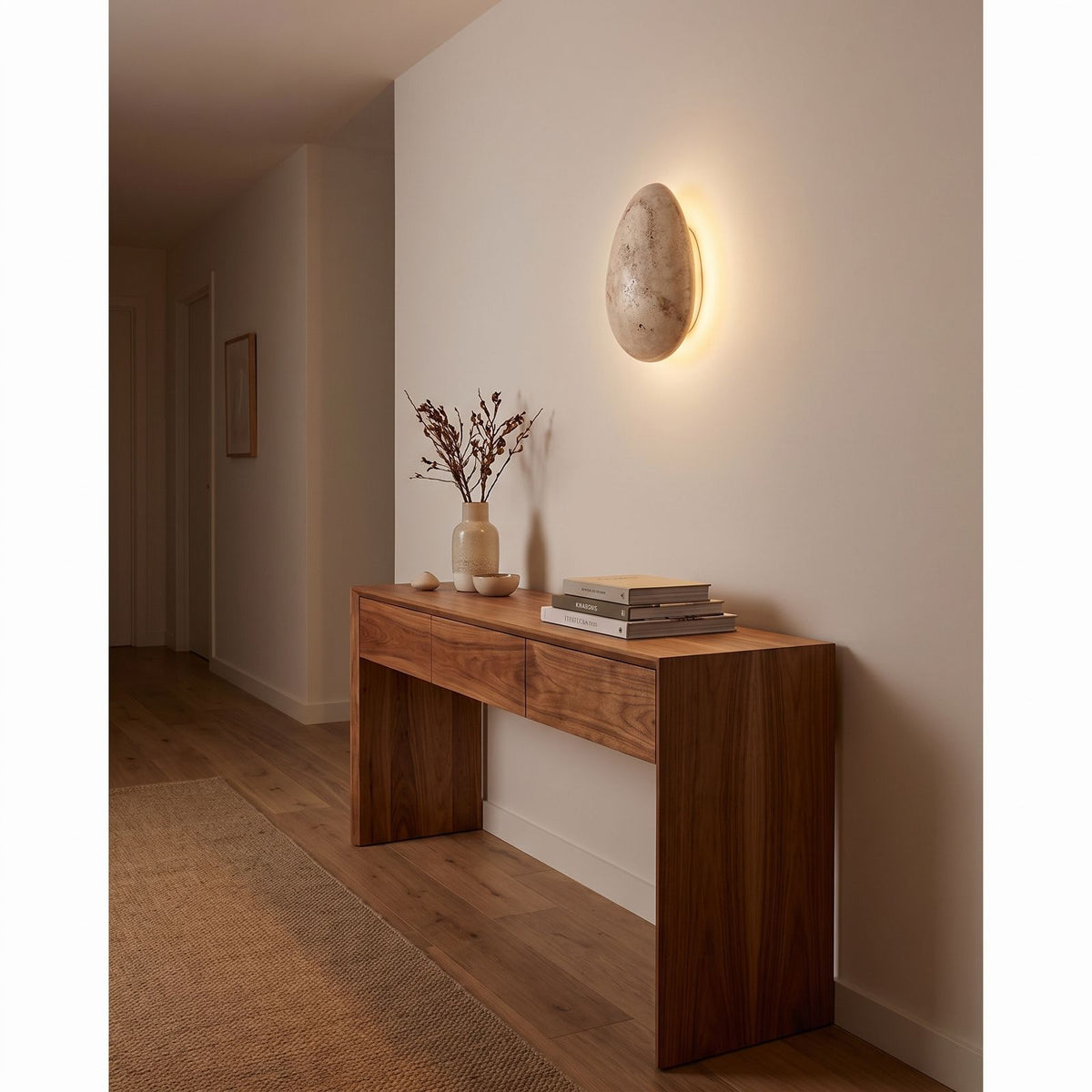 Backlit Floating Pebble Marble Wall Light in a hallway above a timber console