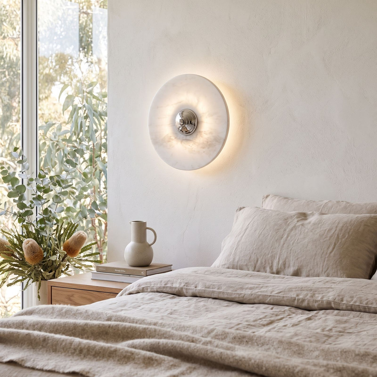 Backlit Marble Disc Touch Wall Light on a bedroom wall beside the bed
