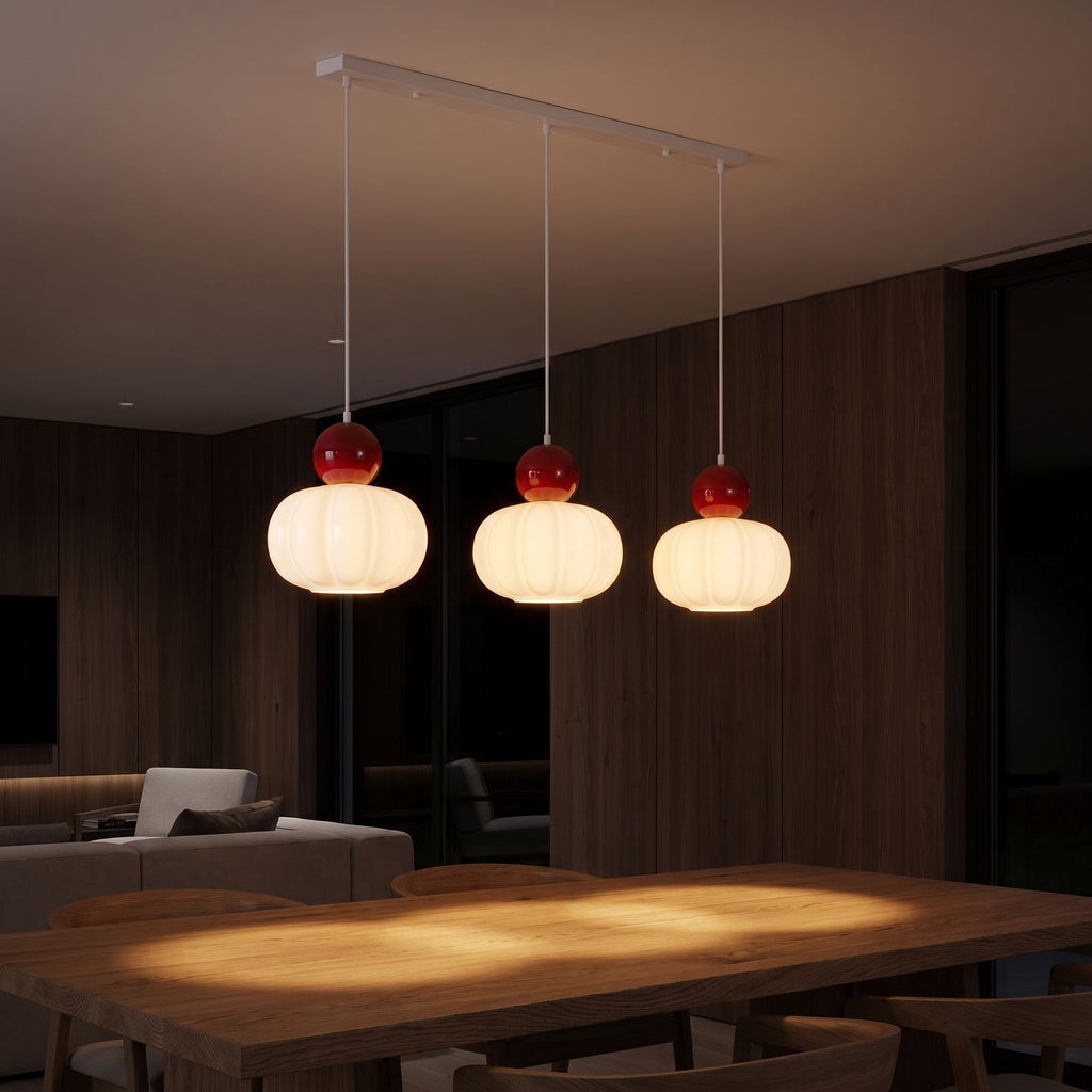 Ball-top scalloped acrylic 3-light pendant over a dining table at night